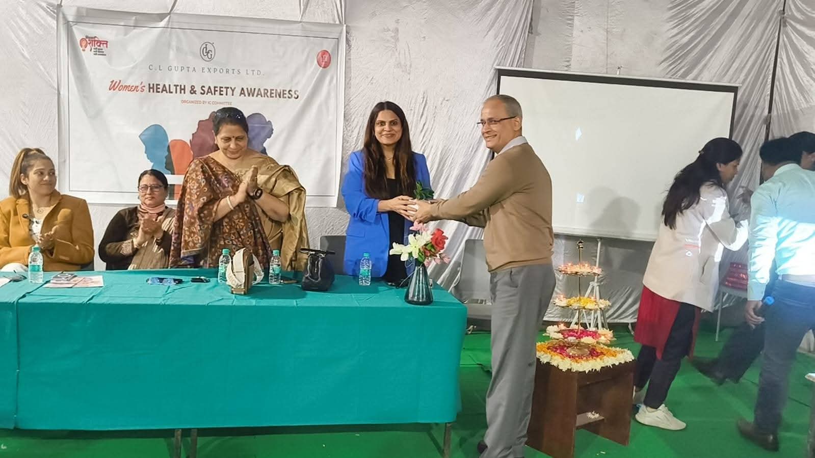 Presenting guest of honor with welcome token plant on seminar stage